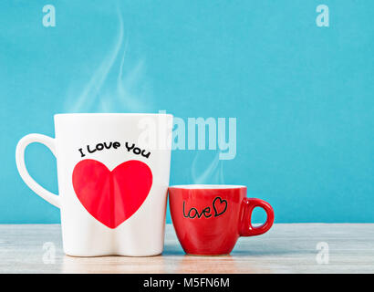 Weiß und rot Tasse heißen Kaffee mit Rauch auf Holztisch und blauem Hintergrund. Liebe Konzept. Stockfoto