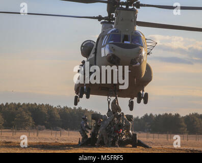Soldaten des 3.BATAILLON zugeordnet, 6 Field Artillery Regiment, 1st Brigade Combat Team, 10 Mountain Division (LI), Sling laden Sie ein M777A2 Howitzer zum Ende einer CH-47 Chinook an Abteilung Hill, Fort Drum, New York, während einer Air Assault Übung, 21. Februar 2018. Stockfoto