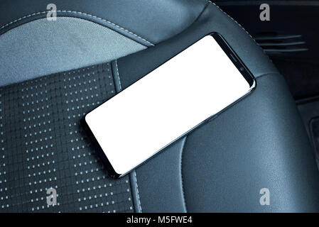 Handy am Autositz. Isolierte Bildschirm für mockup. Schwarz Leder Sitz im Hintergrund. Stockfoto