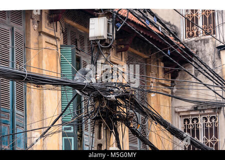 Hunderte von elektrischen Leitungen sind über einen Strommast in gefährlicher Weise in Hanoi, Vietnam gestreut. Dies ist der standard der Power Distribution in ganz Indochina. Stockfoto