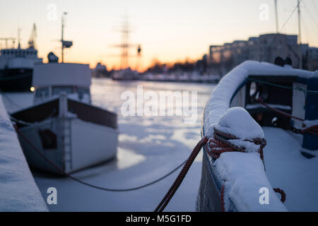 Selektiver Fokus auf Liegeplatz Poller auf dem Boot von Schnee bedeckt im Winter Sonnenuntergang Stockfoto