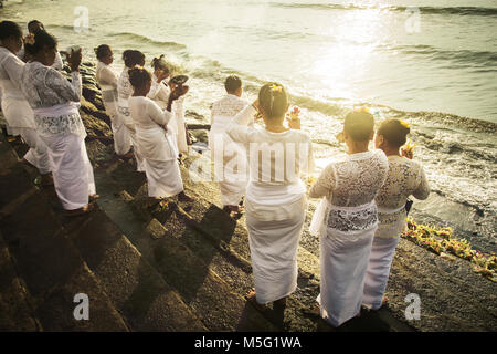 Gruppe der balinesischen hinduistischen Frauen Gott anbeten auf Padang Galak Strand an der Melasti Zeremonie. Einzigartig hohen Winkel über die Schulter schauen in Sun anzeigen Stockfoto