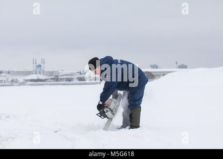 Kasan, Russland - Januar 19, 2017: Russische MoE Rettungsschwimmer Schnitte Eis mit einer Kettensäge - Retter im Winter Tag während der Taufe Christi Urlaub Stockfoto