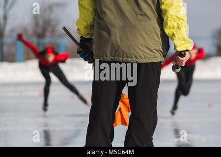 Eisschnelllauf Wettbewerb - Trainer und Sportler auf der Eisbahn - Kinder und Sport Konzept Stockfoto