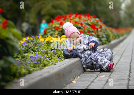 Portrait von Kind - kleines Mädchen mit gefallenen Blätter Wandern im Herbst Park: Baby in der Gasse liegen Stockfoto