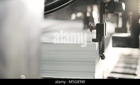 Gedruckte Blätter werden in der Druckmaschine serviert. Offset, CMYK Stockfoto