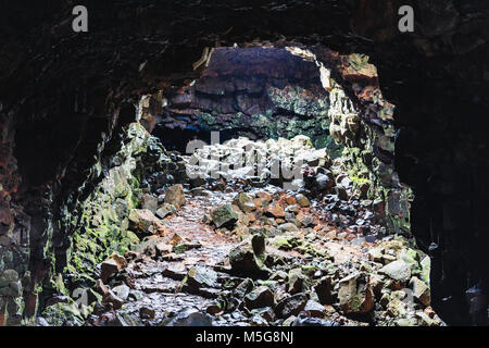 Eine Wanderung durch eine Lava Höhle in Island Tunnel sind sehr schmal und teilweise blockiert Stockfoto