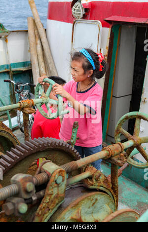 Einen vier Jahre alten philippinischen Mädchen spielt fährt das Schiff mit alten Maschinen auf einer Fähre von Cebu, Bohol in den Philippinen reisen. Stockfoto