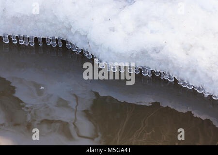 Kleine Runde Eiszapfen über Wasser Stockfoto