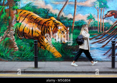 Frau auf dem Handy vorbei Street Art in Shoreditch, East London Stockfoto