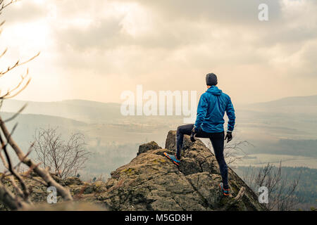 Mann in schönen inspirierenden Berge Sonnenaufgang beten oder feiern. Wanderer-Silhouette auf Berggipfel Wandern oder klettern. Auf der Suche und genießen inspira Stockfoto