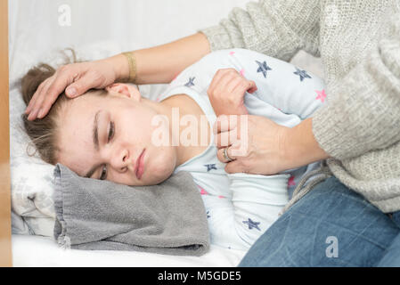 Ein Kind mit Epilepsie während eines Anfalls gepflegt, von einem qualifizierten Betreuer. Stockfoto