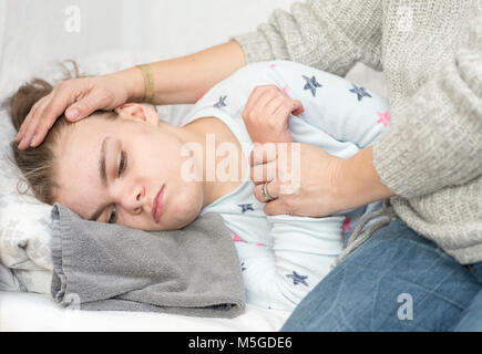 Ein Kind mit Epilepsie während eines Anfalls gepflegt, von einem qualifizierten Betreuer. Stockfoto