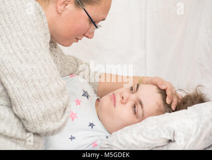 Ein Kind mit Epilepsie während eines Anfalls gepflegt, von einem qualifizierten Betreuer. Stockfoto