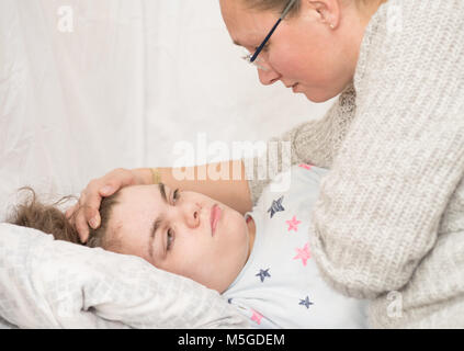 Ein Kind mit Epilepsie während eines Anfalls gepflegt, von einem qualifizierten Betreuer. Stockfoto