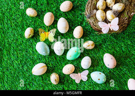 Frohe Ostern geschossen von oben als flatlay mit bunten retro Ostereier, Gras, Butterfly und Osternest Stockfoto