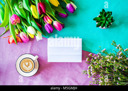 Frohe Ostern Frühling Schuß von oben als flatlay mit leeren Leuchtkasten für Meldung und bunte Tulpen, Blumen und Kaffee Tasse Stockfoto