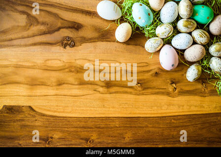 Frohe Ostern geschossen von oben als flatlay mit bunten retro Ostereier und Gras auf hölzernen Tisch Stockfoto