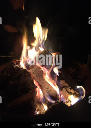 Feuer in der Feuerstelle, das Verbrennen von Holz und die Glut in der Nacht, schwarzen Hintergrund. Stockfoto