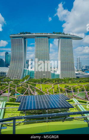 Singapur, Singapur - Januar 30, 2018: in der Nähe von Solar Paneel mit einer schönen Landschaft der drei Türme des Marina Bay Sands Ressort gegen einen bewölkten Himmel hinter, die Welten der teuerste standalone Casino zum Zeitpunkt der Eröffnung im Jahr 2010 in Singapur Stockfoto