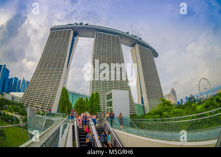 Singapur, Singapur - Januar 30, 2018: Outdoor Ansicht von unbekannten Personen mit einem elektrischen Treppen mit einem schönen drei Türme des Marina Bay Sands Ressort hinter, die Welten der teuerste standalone Casino zum Zeitpunkt der Eröffnung im Jahr 2010 in Singapur, Fischaugen-Effekt Stockfoto