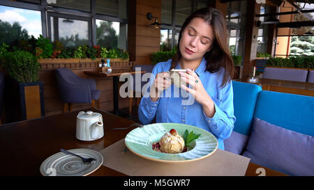 Europäische Mädchen trinken Kaffee im Restaurant und essen Kuchen. Stockfoto