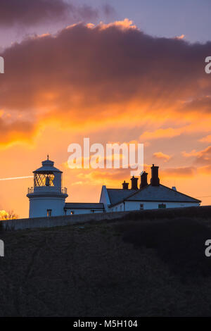 Swanage, Dorset, Großbritannien. 23. Februar 2018. UK Wetter. Einen spektakulären Sonnenuntergang den Tag über Anvil Point Lighthouse in Durlston Country Park in Swanage auf der Dorset Jurassic Coast zu beenden. Foto: Graham Jagd-/Alamy Leben Nachrichten. Stockfoto