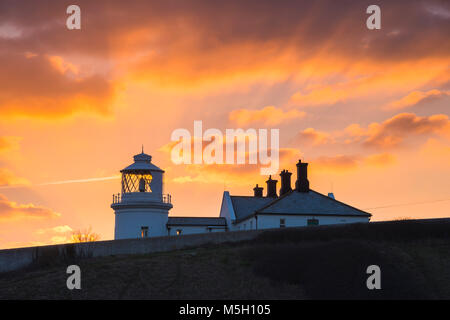 Swanage, Dorset, Großbritannien. 23. Februar 2018. UK Wetter. Einen spektakulären Sonnenuntergang den Tag über Anvil Point Lighthouse in Durlston Country Park in Swanage auf der Dorset Jurassic Coast zu beenden. Foto: Graham Jagd-/Alamy Leben Nachrichten. Stockfoto