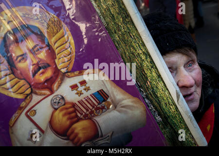 Moskau, Russland. 23 Feb, 2018. Ein Anhänger der Kommunistischen Partei der Russischen Föderation (Cprf) mit einem Porträt von Joseph Stalin bei einer Kundgebung der Cprf in Moskau organisiert zum 100. Geburtstag des Arbeiter- und Bauernregierung" Rote Armee, die das Land- und Luftstreitkräfte der russisch-sowjetischen Föderativen Sozialistischen Republik und später die Streitkräfte der Sowjetunion (UDSSR) Credit: Nikolay Winokurow/Alamy Leben Nachrichten zu feiern. Stockfoto