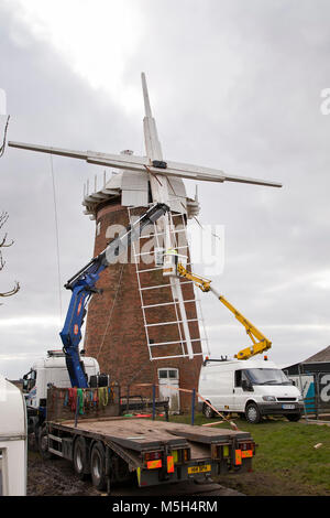 Norfolk Broads, UK. 23. Februar 2018. Horsey Windpump Entwässerung Mühle erhält es Vertrieb zurück nach vier Jahren entfernt wird, Teil einer National Trust Restaurierungsprojekt. Aufgrund der weichen Boden ein Tieflader mit Hiab Kran wurde verwendet, um die Verkäufe nacheinander in die richtige Position zu heben. Millwright Tim Wittling und seine Crew arbeitete für fast 12 Stunden in dem sehr kalten und eine leichte Brise, die Sicherung der letzten Segel in der Abenddämmerung. Die Fensterläden sind neben neu installiert werden und es wird gedacht, dass der Umsatz wieder drehen bis Juni. Foto: Adrian Buck/Alamy Leben Nachrichten. Stockfoto