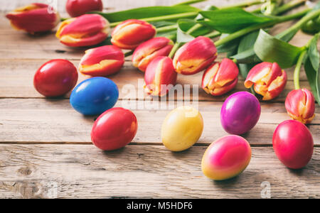 Frühling. Ostereier und frischen Tulpen auf Holz- Hintergrund, kopieren Raum Stockfoto