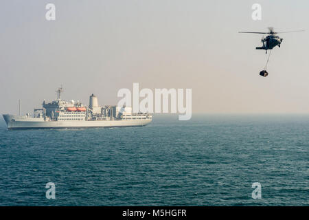 ARABIAN GULF (Feb. 8, 2018) Eine MH-60S Sea Hawk Hubschrauber liefert Cargo in den geführten-missile Cruiser USS Bunker Hill (CG52) während einer vertikalen Auffüllung mit der Britischen Royal Fleet Auxiliary (RFA) Fort Rosalie (A 385). Bunker Hill ist mit der Theodore Roosevelt Carrier Strike Group in die USA 5 Flotte Bereich für Maßnahmen zur Erhöhung der Sicherheit im Seeverkehr im Einsatz Verbündeten und Partnern zu beruhigen und der Freiheit der Schiffahrt und des freien Handels in der Region erhalten. (U.S. Marine Stockfoto