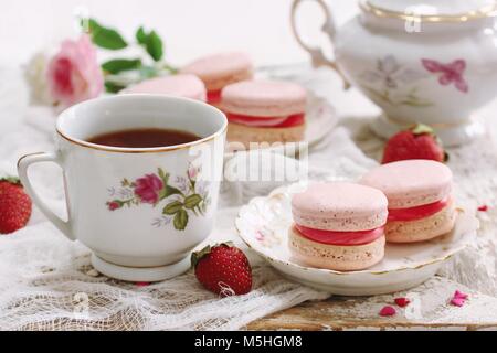 Hausgemachte Rosa Makronen oder Macarons mit einer Tasse Kaffee/Valentines Tag Dessert für Zwei auf rustikalen Holzrahmen Stockfoto