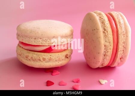 Nahaufnahme von HAUSGEMACHTEN zwei Rosa Macarons/Makronen, selektiver Fokus/Valentines Tag essen Dessert für Zwei Stockfoto