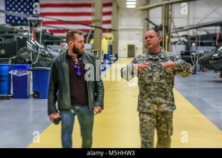 Oberstleutnant Glen McElroy, rechts, gibt Cpl. Rory Hamill, ein Kampf - verletzte Marine, eine Tour der New Jersey National Guard Army Aviation Support Service auf Joint Base Mc Guire-Dix - Lakehurst, New Jersey, Dez. 21, 2017. McElroy ist der Kommandant der 1-150 th Assault Helicopter Bataillon. (U.S. Air National Guard Stockfoto