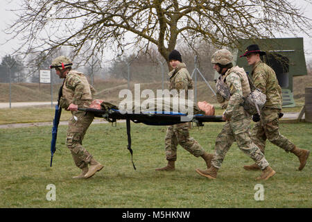 Spc. Wesley Hobson (R) in die 4. Staffel, 2d-Cavalry Regiment zugeordnet, und Sgt. Staci Daniel (R), zur 1. Staffel, 2CR, Spaziergang mit Soldaten aus 11 Leichte Infanterie Bataillon, 1 Infanterie Brigade der Georgischen Land Kräfte, wie sie in einem simulierten Unfall auf eine Landing Zone während einem Kampf Life Saver Kurs evakuieren Feb 9, 2018 an der Medizinischen Simulation Training Center in Grafenwöhr Training Area, Deutschland zugewiesen. Die soldaten Instruktion der Kurs vom 2.Kavallerie Regiments und 7th Army Training Befehl. ( Stockfoto