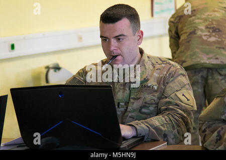 1. Lt Evan Finnane, 1.BATAILLON, 7 Field Artillery Regiment, 2. gepanzerte Brigade Combat Team, 1.Infanterie Division Forschung ein Feld manuelle während eines Paladin Führer Kurs schriftliche Prüfung am 13.02.2018, Grafenwöhr, Deutschland. Die schriftliche Prüfung ist Teil eines einwöchigen Paladin Schulung für Führungskräfte zu platoon Zuweisungen Übergang zu unterstützen. (U.S. Armee Stockfoto