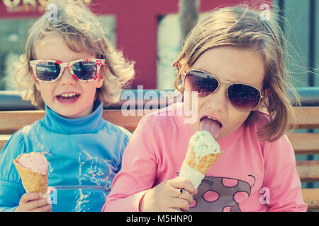 Zwei kleine Mädchen (Schwestern) Eis essen. Stockfoto