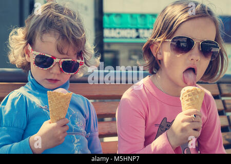 Zwei kleine Mädchen (Schwestern) Eis essen. Stockfoto