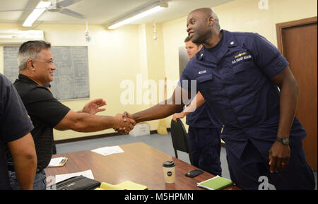 Cmdr. Ulysses Mullins, Stellvertretender Sektor Kommandant Küstenwache Sektor Honolulu schüttelt die Hand des stellvertretenden Port Regisseur Gus Godinet, nach einem Briefing der Beamten aus dem Hafen von Pago Pago Amerikanisch-Samoa Environmental Protection Agency, American Samoa Abteilung der Marine & Wildlife Reserve, National Marine Sanctuary von Amerikanisch-samoa sowie die verantwortliche Partei am Hafen Pago Pago in Bezug auf die Reaktion Bemühungen an Bord der 88-Fuß-kommerziellen Fischereifahrzeug Chui Zai Fa Nr. 1 geerdet über 300 Yards weg Leone Bay, Amerikanisch-Samoa, Feb.12, 2018. Der Eigentümer der Chu Zai Fa Nr. 1, der Respons Stockfoto