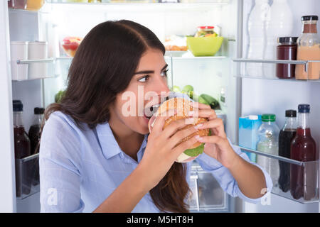 Portrait einer jungen Frau Burger essen Stockfoto