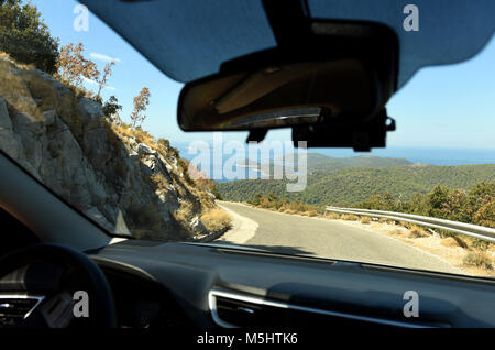 Blick aus dem Auto durch die Windschutzscheibe. Straße auf Insel, Serpentine, Reise, Kroatien Stockfoto