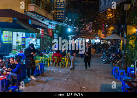 Die Menschen essen an Street Food Cafes bei Nacht, Hanoi, Vietnam. Stockfoto