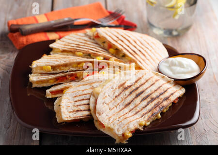 Vegetarische quesadilla mit Paprika, Mais, Käse und saurer Sahne. Selektiver Fokus auf der Vorderseite Keil Stockfoto