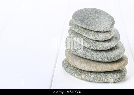 Vom spa Steine machen Salden Pyramiden auf weißem Holz- Hintergrund Stockfoto