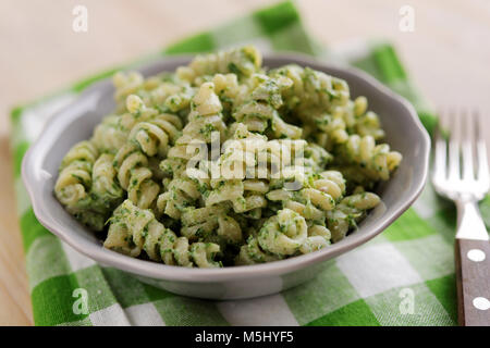 Fusilli mit Spinat und Ricotta in eine Schüssel geben. Stockfoto