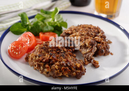 Schnitzel in Walnüssen und Gemüse auf einer Platte closeup Stockfoto