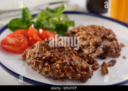 Schnitzel in Walnüssen und Gemüse auf einer Platte closeup Stockfoto