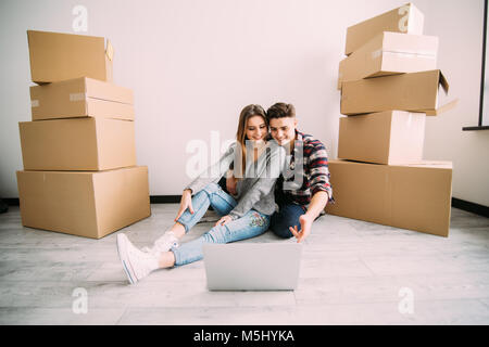 Das junge Paar auf der Suche nach Appartements mit Laptop. Verschieben, Erwerb von neuen Behausung. Stockfoto