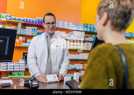 Apotheker erklären Medizin an den Kunden in der Apotheke Stockfoto